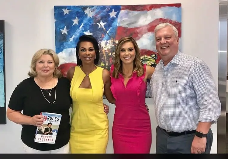 Lisa Boothe standing with her parents and a TV co-host.